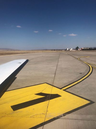 Cropped image of airplane on airport runway against sky