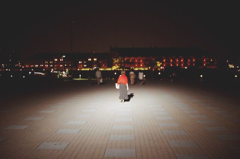 Woman in illuminated city at night