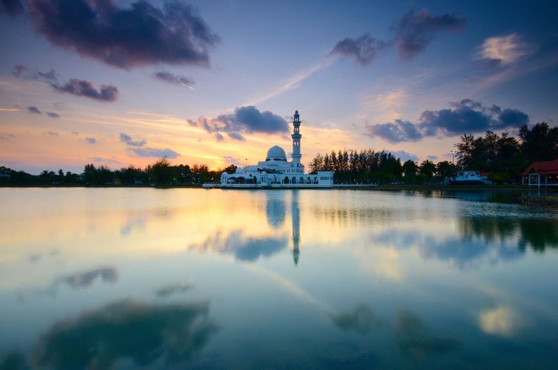 Reflection of mosque on water at sunset