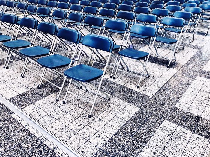Empty blue chairs on floor outdoors