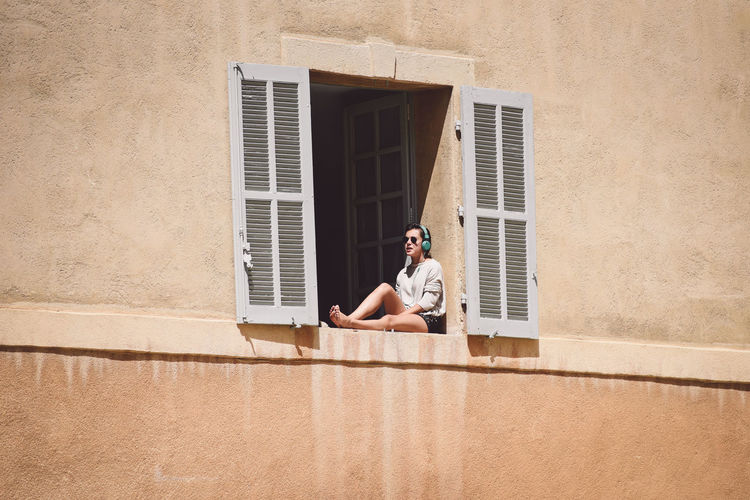 A young woman taking sunbathe Casual Casual Clothing Day Girl Leisure Activity Lifestyles Relax Rest Summer Sun Sunbath Sunbathe Sunbathing Sunshine Vacation Weekend Window Woman Youth