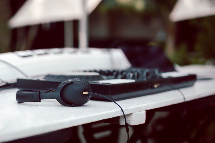 Black headphones and professional mixing console on table