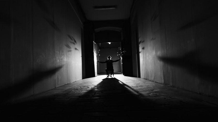 View of woman sitting in illuminated corridor