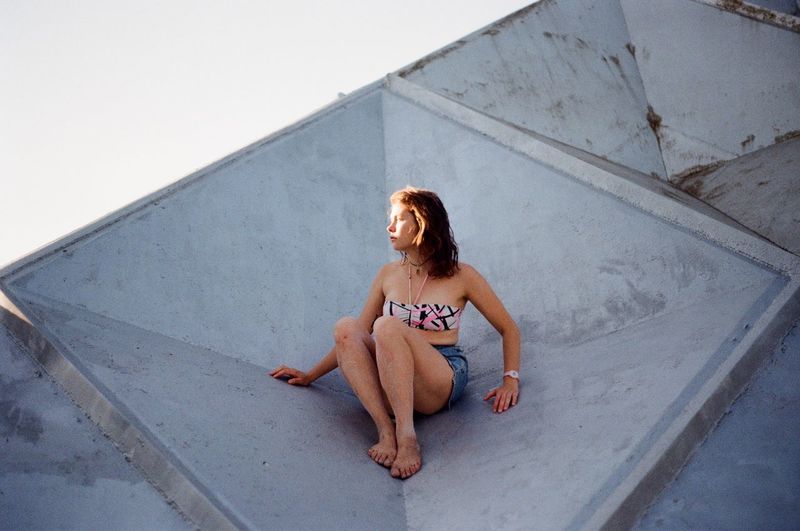 High angle view of woman sitting on rooftop