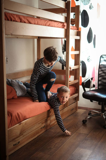 Brothers play and fight in a real interior, the concept of the opposition of siblings and family 