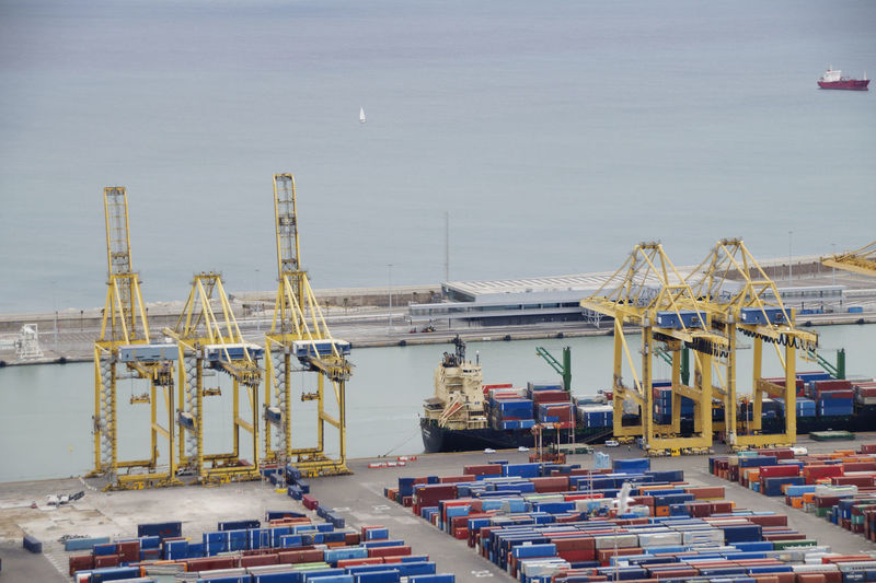 Commercial dock with cargo container and cranes by sea against sky, barcelona 