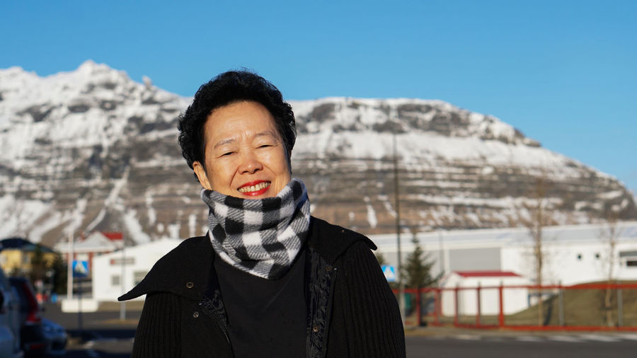 Portrait of woman standing against mountain during winter