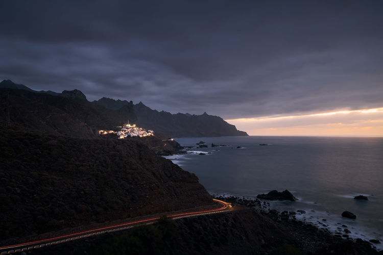 Cliffs in north coastline of tenerife at moody sunset. village in anaga mountains, tenerife.