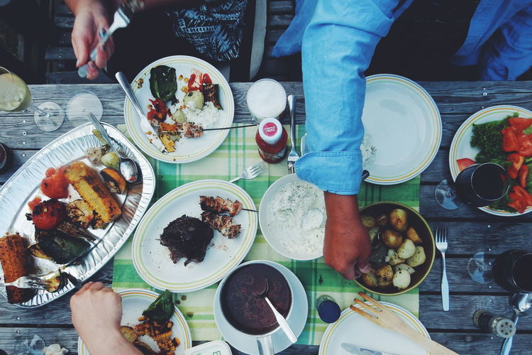 Cropped image of people having food at table