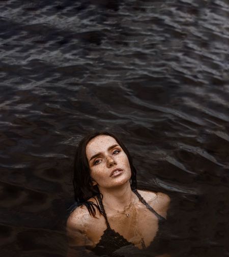 High angle portrait of young woman swimming in lake