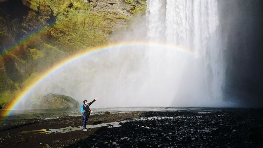 Full length of man standing by waterfall