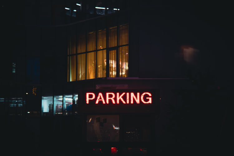 Information sign on illuminated street in city at night