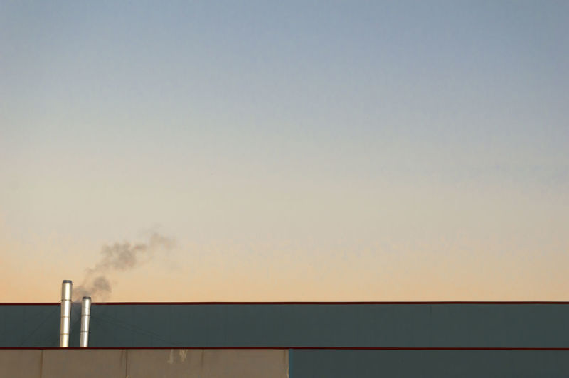 Smoke emitting from chimney against sky during sunset