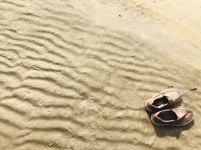 Close-up of shoes on sand