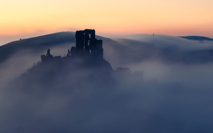 Silhouette of corfe castle against sky during sunrise