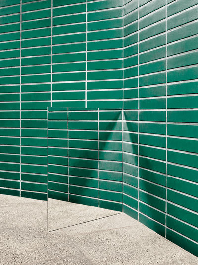 Mirror against green wall
