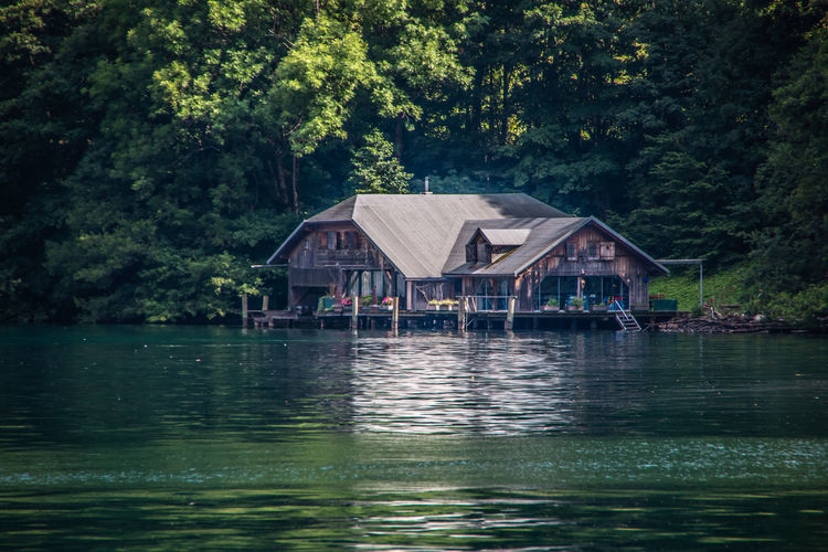 House by lake against trees in forest