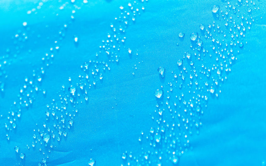 Full frame shot of raindrops on blue glass