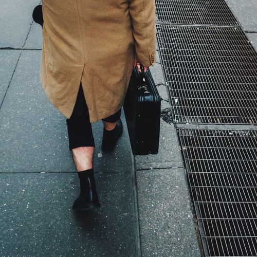 Low section of man standing on zebra crossing