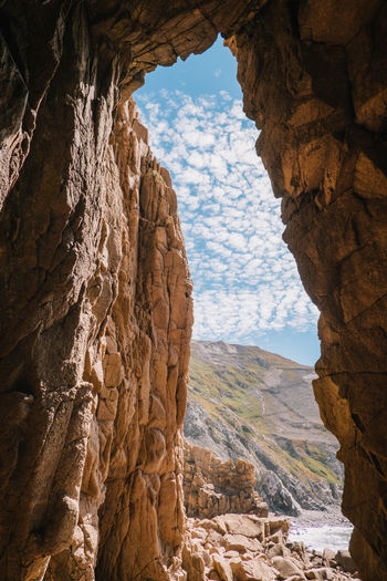 Rock formations at beach against blue sky