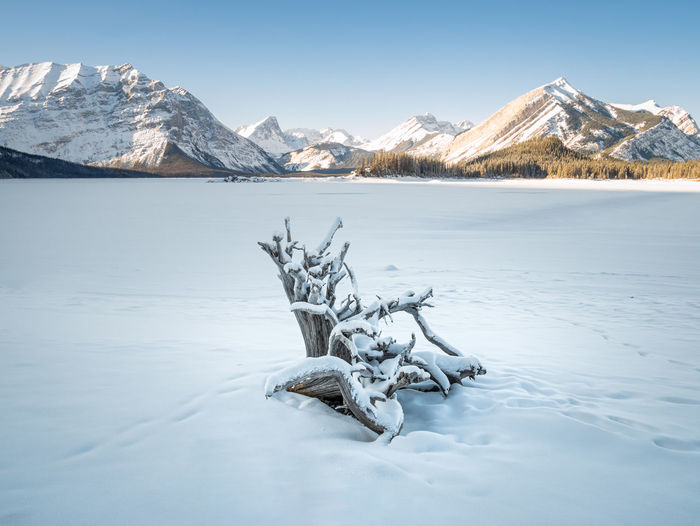 Alpine lake surrounded by mountains and snow during winter, upper kananaskis lake, canada