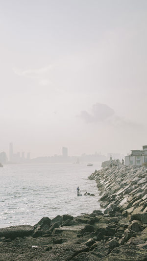 Scenic view of sea by buildings against sky