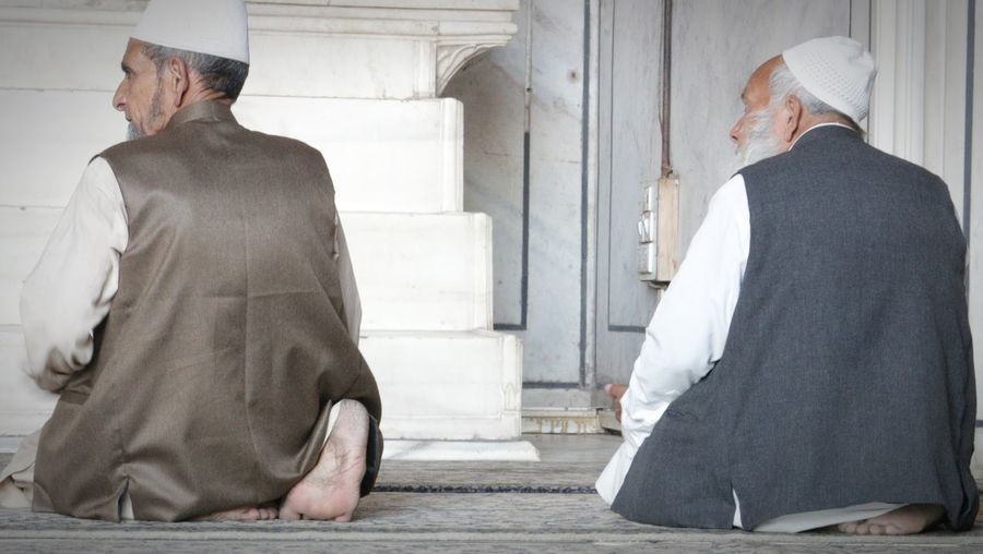Rear view of men praying in mosque