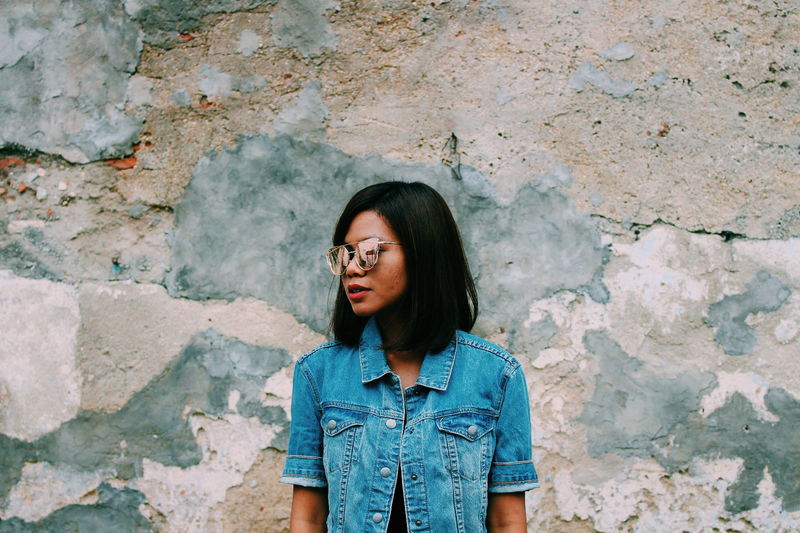 Beautiful woman standing against blue wall