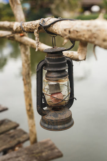 Close-up of old lantern hanging on wooden post
