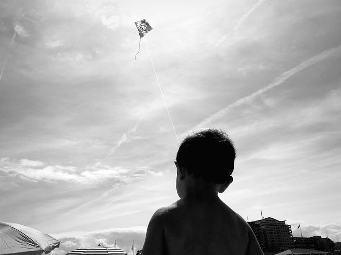 Low angle view of boy looking at sky