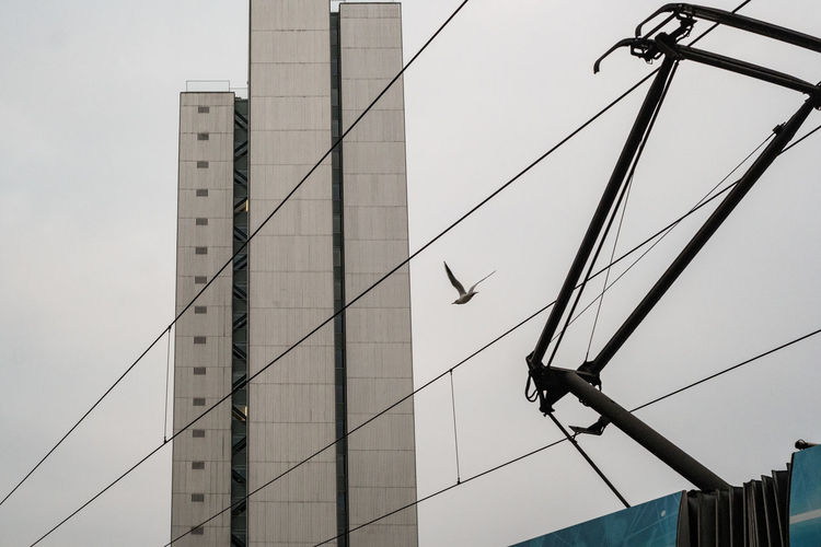 Low angle view of electricity pylon against clear sky