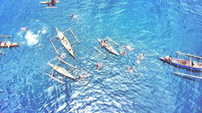 High angle view of outrigger boat in blue sea