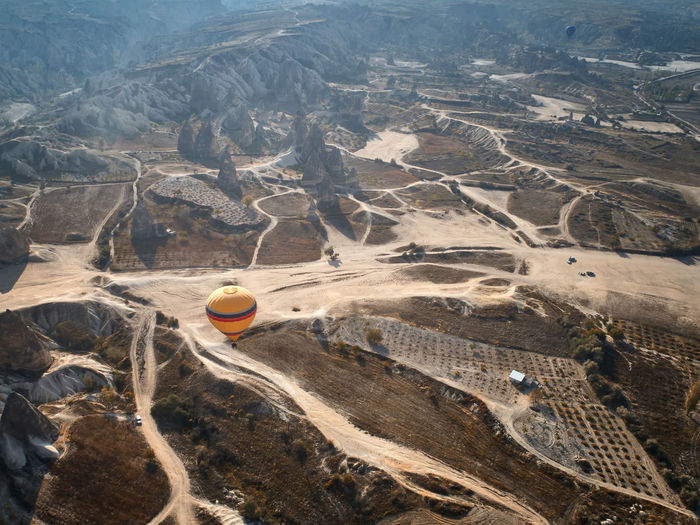 Aerial view of hot air balloon over landscape against sky