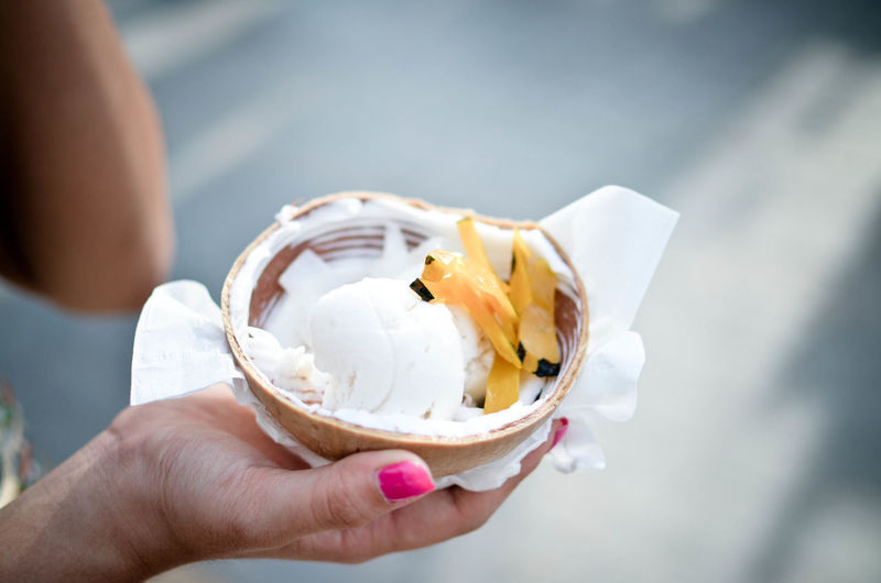Cropped image of woman coconut ice cream