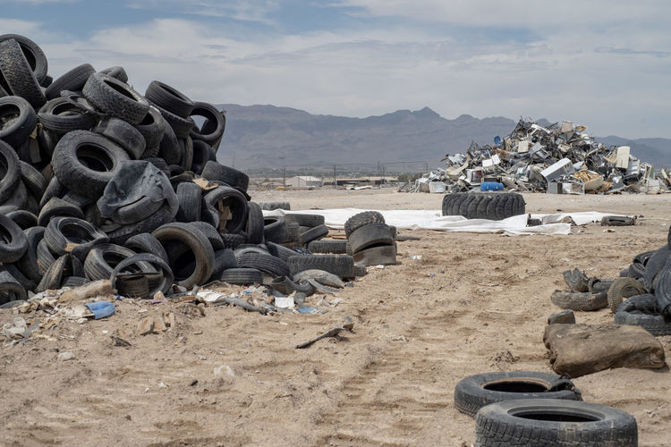 Piles of worn out tires in mojave desert landscape with mountain range in background