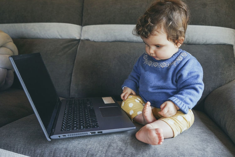 Man using mobile phone while sitting on sofa at home