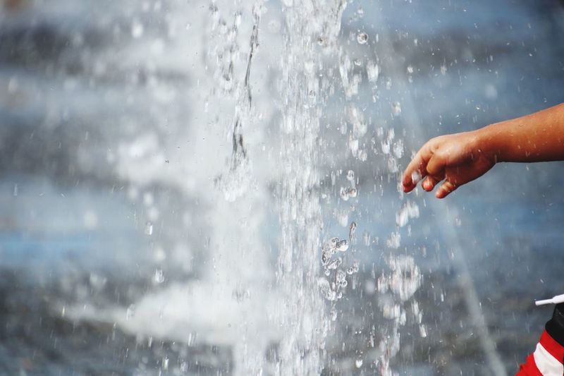 Midsection of woman splashing water