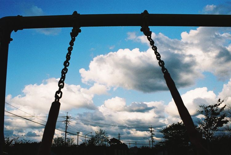 Low angle view of silhouette chain against sky