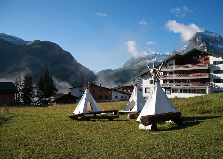 View of tipis in front of residential buildings
