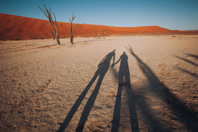 Shadow of people on sand dune
