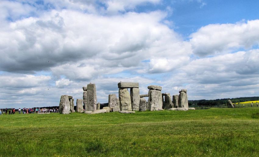 Stonehenge on grassy field against sky