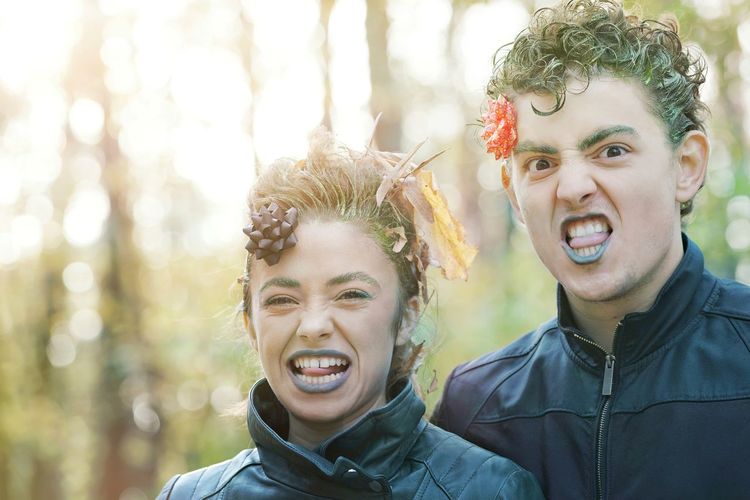 Portrait of young couple making faces in forest