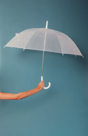 Low angle view of umbrella against blue background