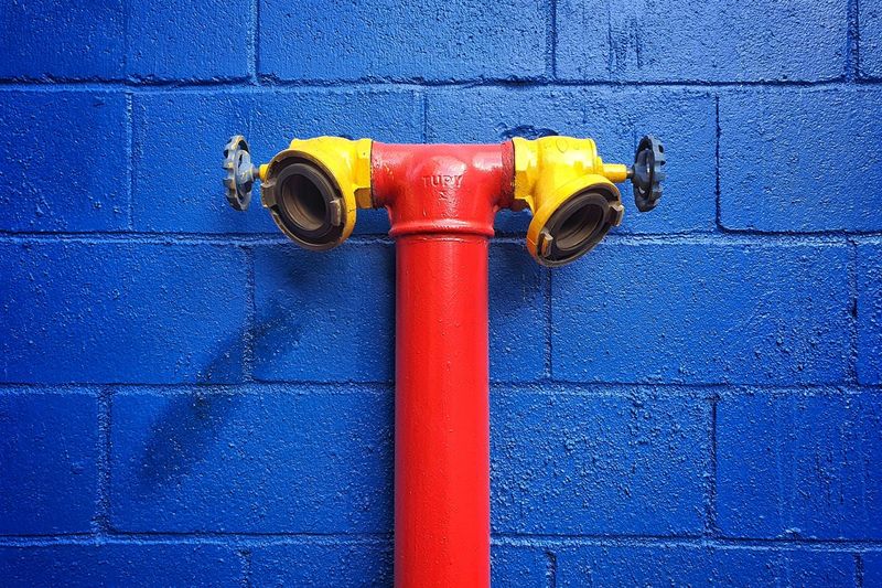 Close-up of fire hydrant against blue wall