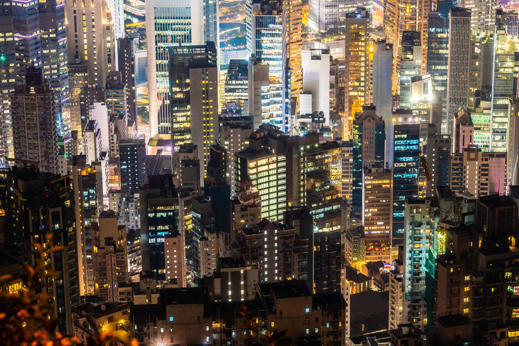 Illuminated buildings at victoria harbour in city during night