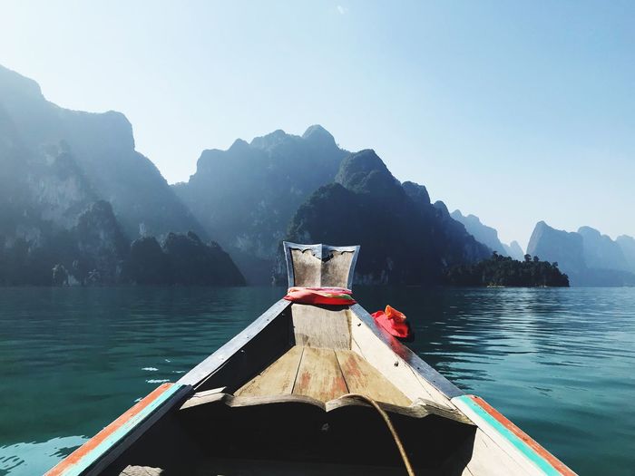 Boat moored on lake against mountain range