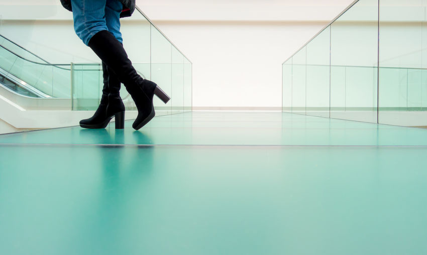 Low section of woman standing on glass floor