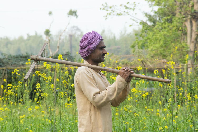 Farmer holding spade standing on field
