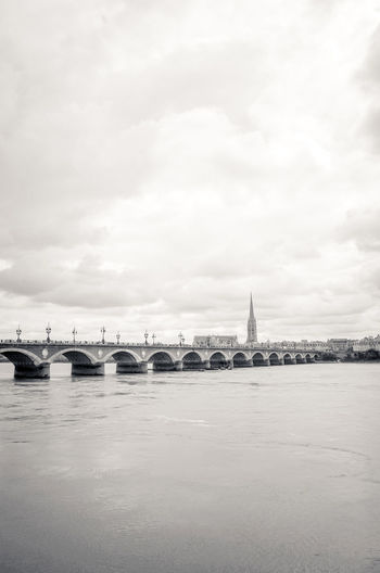 Pont de pierre bridge over river against cloudy sky