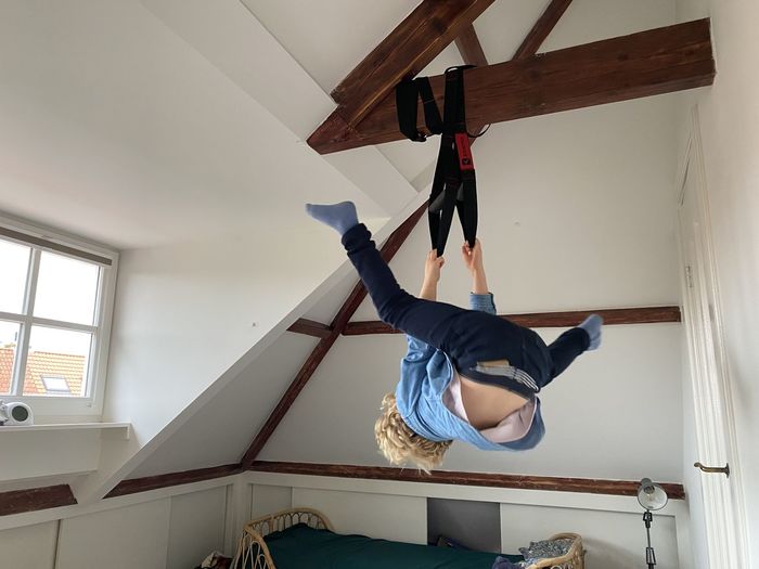 Low angle view of boy hanging at home